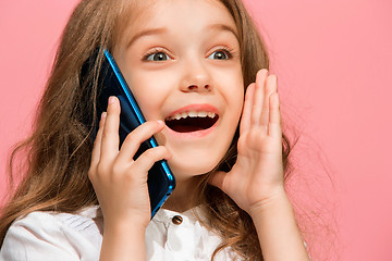 Image showing The happy teen girl standing and smiling against pink background.