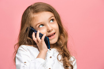 Image showing The happy teen girl standing and smiling against pink background.