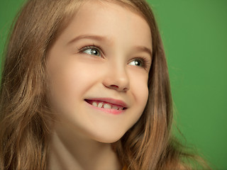 Image showing The happy teen girl standing and smiling against green background.