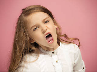 Image showing Portrait of angry teen girl on a pink studio background