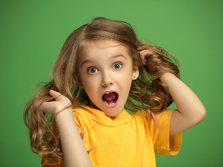 Image showing The happy teen girl standing and smiling against green background.