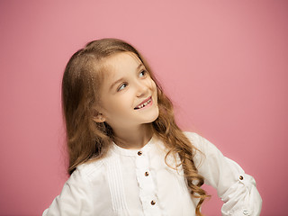 Image showing The happy teen girl standing and smiling against pink background.