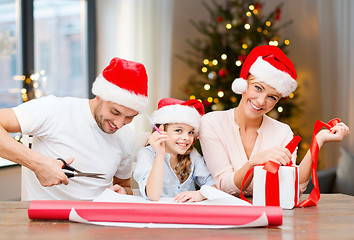 Image showing happy family wrapping christmas gifts at home