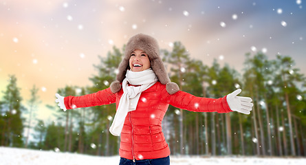 Image showing happy woman in fur hat over winter forest and snow