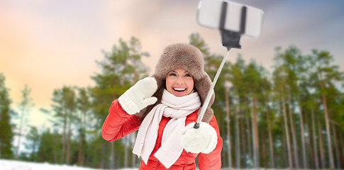 Image showing happy woman taking selfie over winter forest