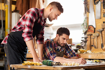 Image showing carpenters with blueprint working at workshop