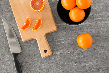 Image showing close up of oranges and knife on cutting board