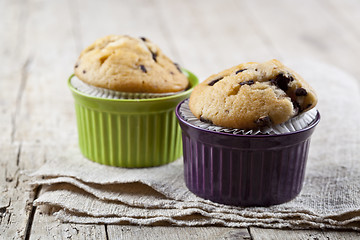 Image showing Homemade fresh muffins on ceramic bowls on linen napkin.