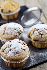 Image showing Two fresh homemade muffins with sugar powder and metal strainer 