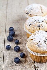 Image showing Homemade fresh muffins with blueberries on rustic wooden table b