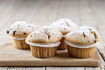 Image showing Homemade fresh muffins with sugar powder on cutting board rustic