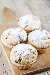 Image showing Homemade fresh muffins with sugar powder on cutting board rustic