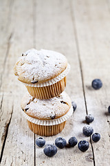 Image showing Two fresh homemade muffins with blueberries on rustic wooden tab