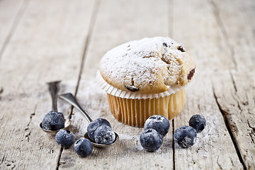 Image showing Homemade fresh muffin with sugar powder, vintage spoons and blue