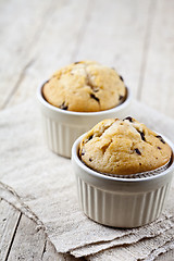 Image showing Two homemade fresh muffins on ceramic white bowls on linen napki