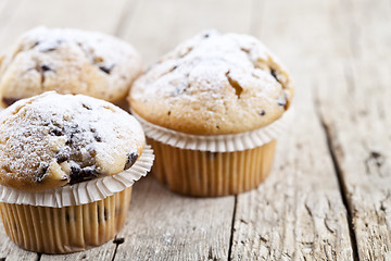 Image showing Homemade fresh muffins with sugar powder closeup on rustic woode