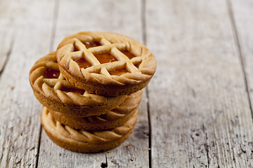 Image showing Fresh baked tarts with marmalade or apricot jam filling on on ru