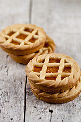 Image showing Fresh baked tarts with marmalade or apricot jam filling on on ru