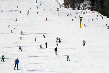 Image showing Lots of skiers and snowboarders on the slope at ski resort 