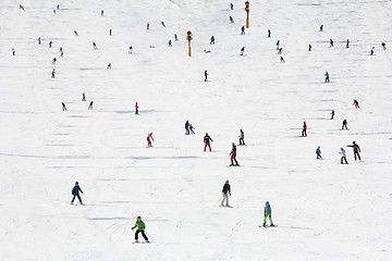 Image showing Lots of skiers and snowboarders on the slope at ski resort 