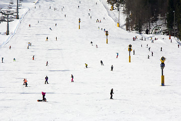 Image showing Lots of skiers and snowboarders on the slope at ski resort 