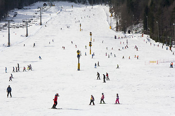 Image showing Lots of skiers and snowboarders on the slope at ski resort 