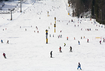 Image showing Lots of skiers and snowboarders on the slope at ski resort 