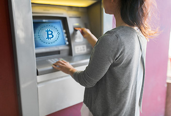 Image showing close up of woman inserting card to atm machine