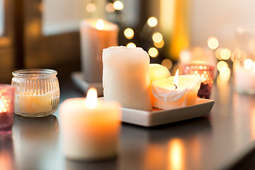 Image showing candles burning on window sill with garland lights