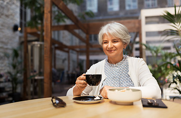 Image showing senior woman drinking coffee at street cafe