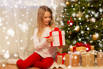 Image showing smiling girl with christmas gift at home