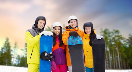 Image showing happy friends in helmets with snowboards outdoors