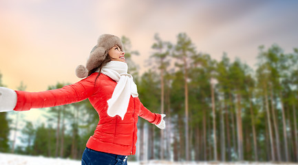 Image showing happy woman in fur hat over winter forest