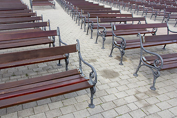 Image showing Lot of Rows of empty brown wooden benches 