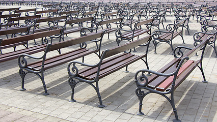 Image showing Lot of Rows of empty brown wooden benches 