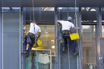 Image showing Window washers cleaning the windows of shopping center