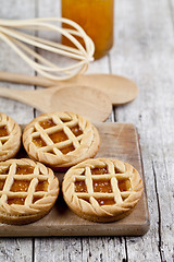 Image showing Fresh baked tarts with marmalade or apricot jam filling and on c