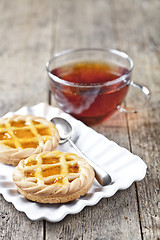 Image showing Fresh baked tarts with marmalade or apricot jam filling on white