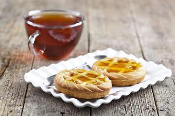 Image showing Fresh baked tarts with marmalade or apricot jam filling on white