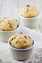 Image showing Homemade fresh muffins on ceramic white bowls on linen napkin on