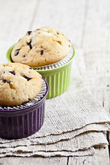 Image showing Homemade fresh muffins on ceramic bowls on linen napkin on rusti