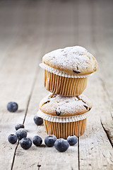 Image showing Two fresh homemade muffins with blueberries on rustic wooden tab