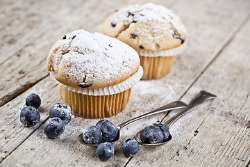 Image showing Homemade fresh muffin with sugar powder, vintage spoons and blue