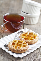 Image showing Fresh baked tarts with marmalade or apricot jam filling on white