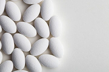 Image showing Pile of white drug pills laying on white background. 