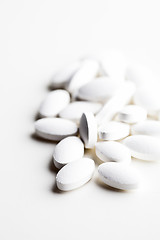 Image showing Pile of white drug pills laying on white background.