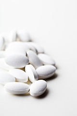 Image showing Pile of white drug pills laying on white background.