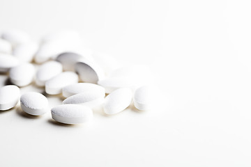 Image showing Pile of white drug pills laying on white background.