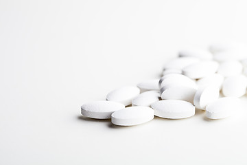 Image showing Pile of white drug pills laying on white background.