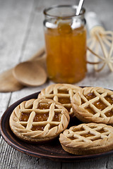 Image showing Fresh baked tarts with marmalade or apricot jam filling and on c